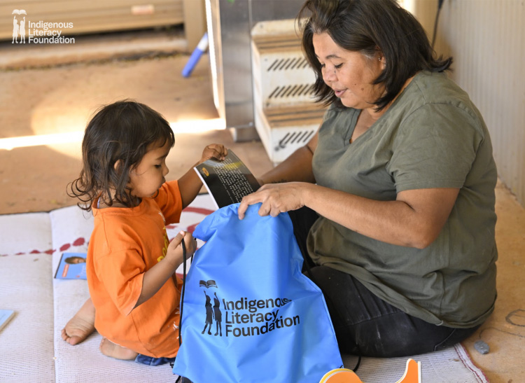 En kvinna och ett barn packar böcker i en tygkasse